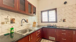 Fully equipped modular kitchen with refrigerator and utensils at Vasantha’s Home Stay by Le Hotel Host in Thillainagar, Trichy